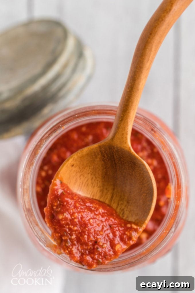 How to make homemade pizza sauce. You likely have all the ingredients in your pantry! Learn how to make your own pizza sauce and freeze it for later too! #pizzasauce #pizzasaucerecipe #howtomakepizzasauce #amandascookin pizza sauce on a spoon