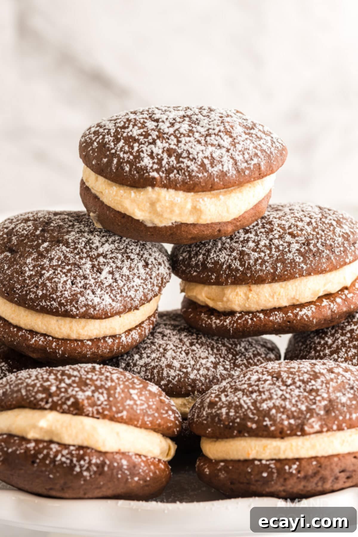 A perfect stack of mini pumpkin whoopie pies, ready to be enjoyed as a sweet fall indulgence. a stack of freshly baked pumpkin whoopie pies, lightly dusted with powdered sugar, showcasing their perfect texture