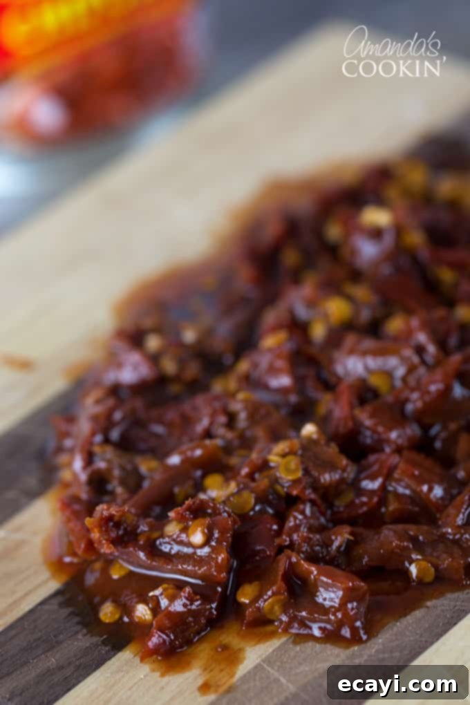 Chipotle Chicken Comfort Bowl 4 A close up of chopped chipotle chili peppers on a wooden cutting board.