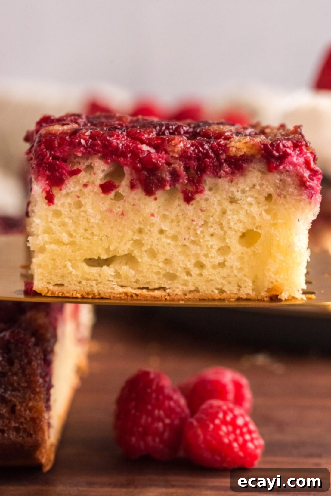 Ruby Raspberry Reveal 2 Square of Raspberry Upside Down Cake lifted up on a spatula