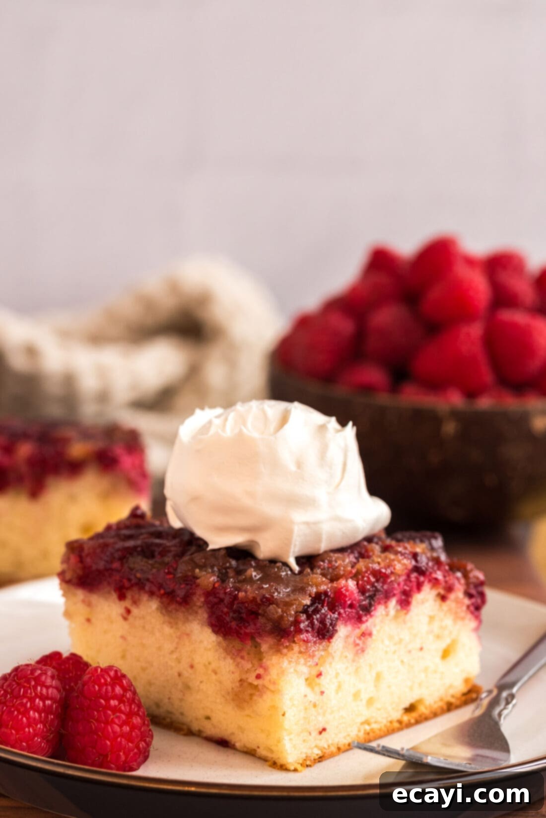 Ruby Raspberry Reveal 14 Raspberry Upside Down Cake on a plate topped with whipped cream