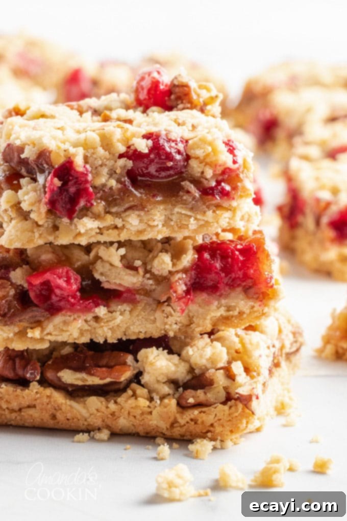 Caramel Cranberry Bliss Bars 2 cranberry caramel bars stacked on each other, showcasing their layers and festive colors