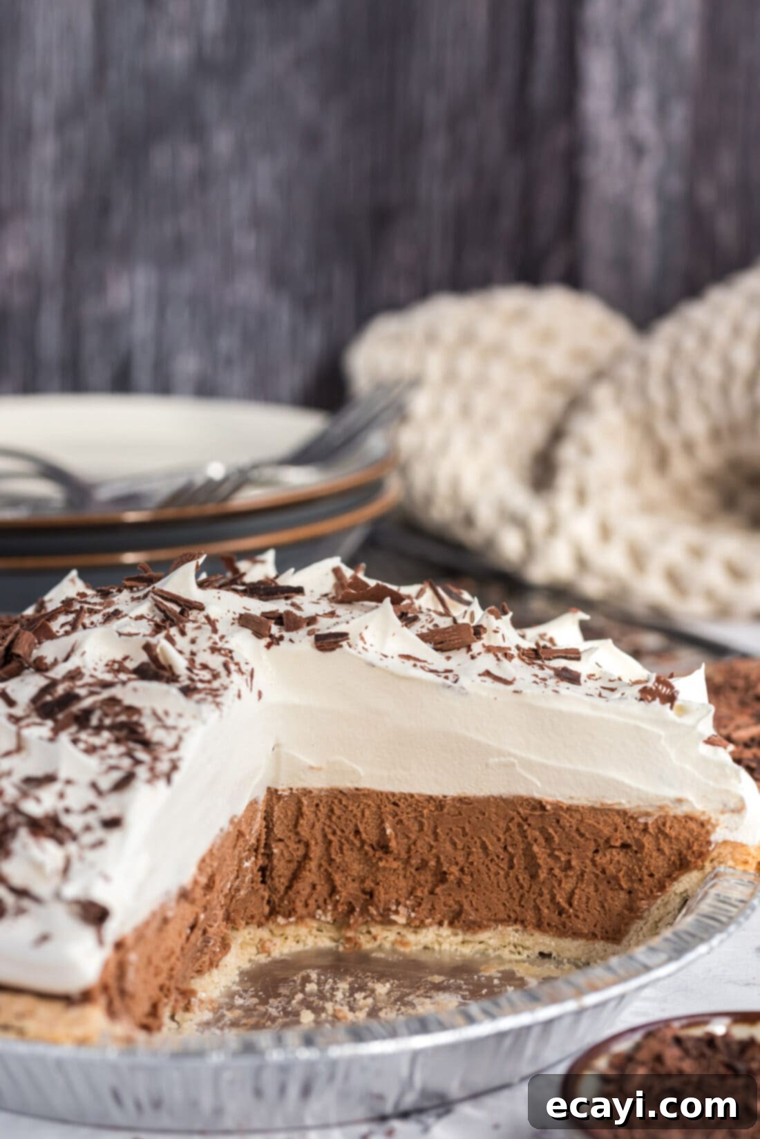 Silky Chocolate Dream 3 A French Silk Pie with several slices already removed, showing the creamy texture of the chocolate filling and the generous topping of whipped cream, ready for serving.