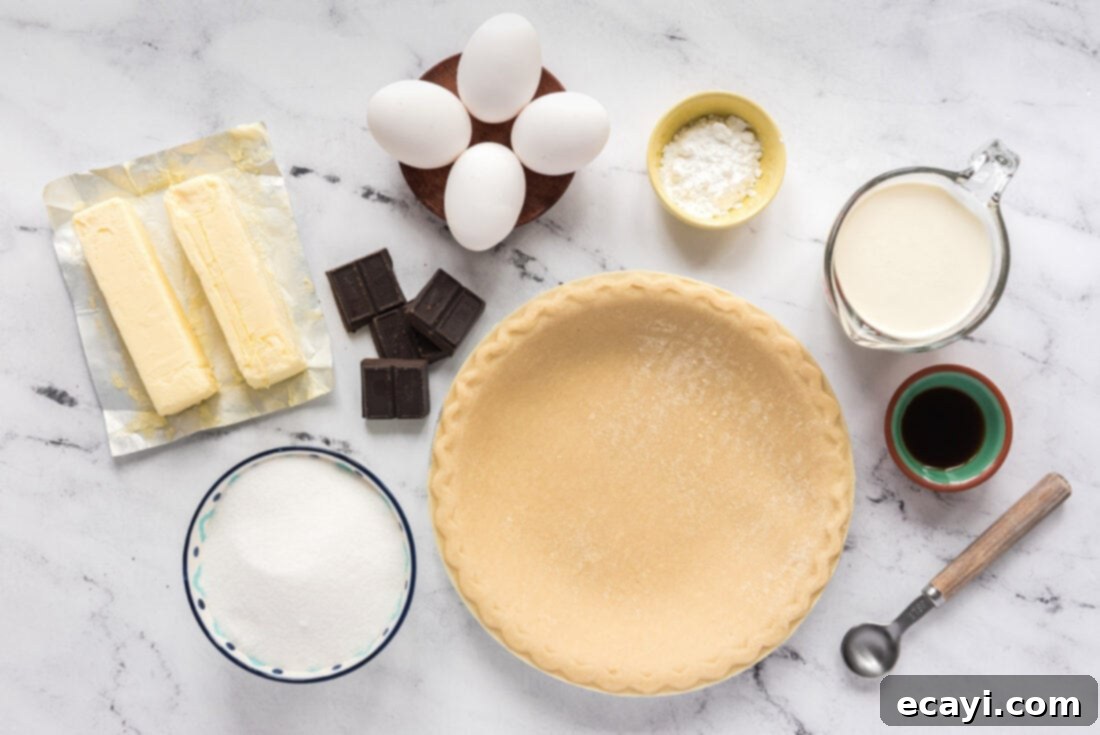 Silky Chocolate Dream 4 All the core ingredients for French Silk Pie laid out on a kitchen surface: butter sticks, a bowl of granulated sugar, unsweetened chocolate squares, a bottle of vanilla extract, and fresh eggs.