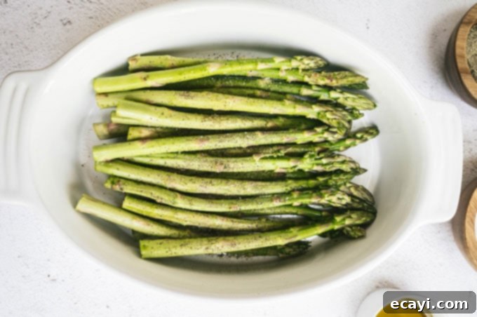 Smoky Green Spears 4 asparagus in a dish with salt and pepper in dishes around it