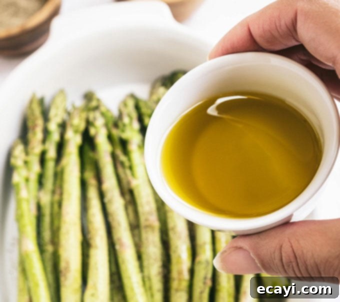 Smoky Green Spears 5 hand holding dish of olive oil with asparagus in the background
