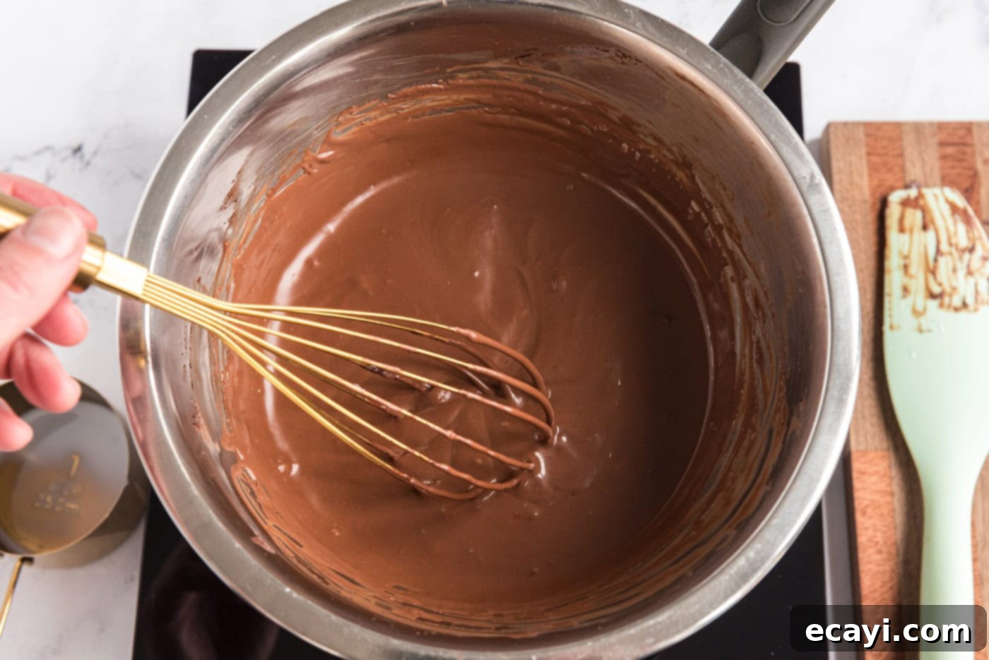 Decadent Homemade Chocolate Ice Cream 7 Smooth milk and melted chocolate mixture in a bowl with a whisk resting in it, after being removed from heat and allowed to cool