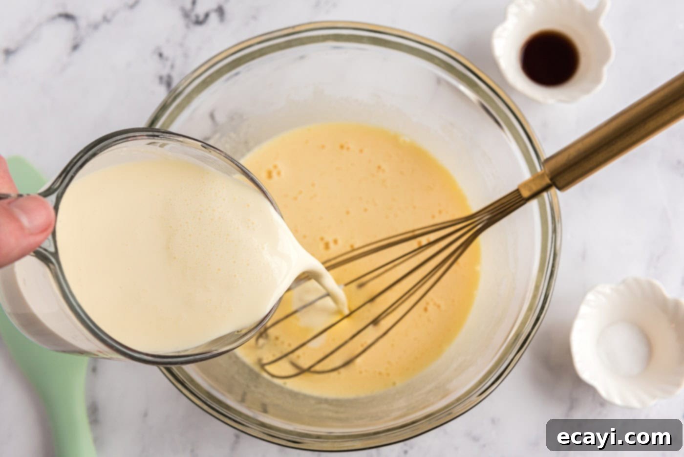 Decadent Homemade Chocolate Ice Cream 10 Pouring heavy cream into a bowl containing whisked eggs and sugar mixture