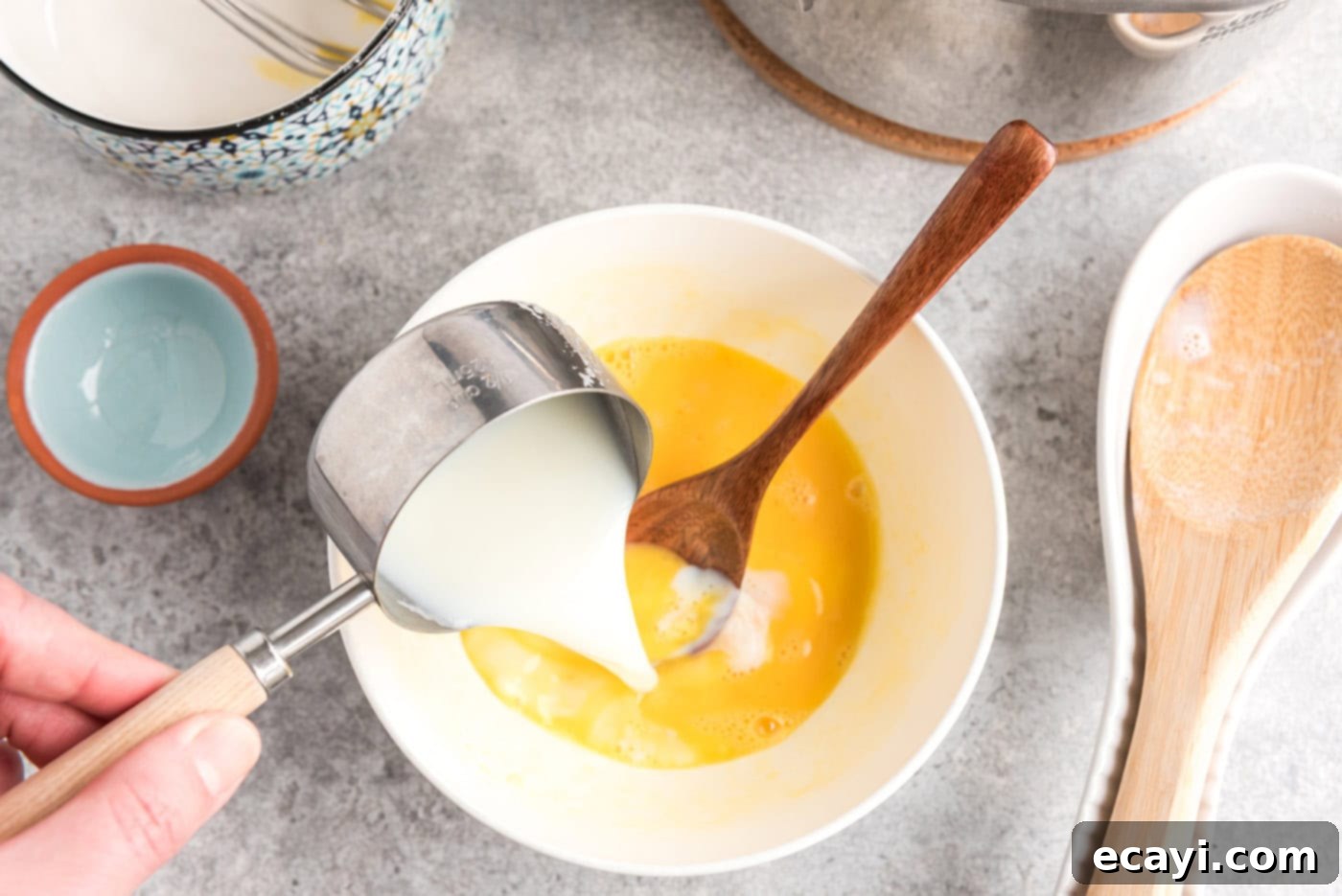 The Ultimate Homemade Vanilla Ice Cream 6 pouring milk into bowl of beaten eggs