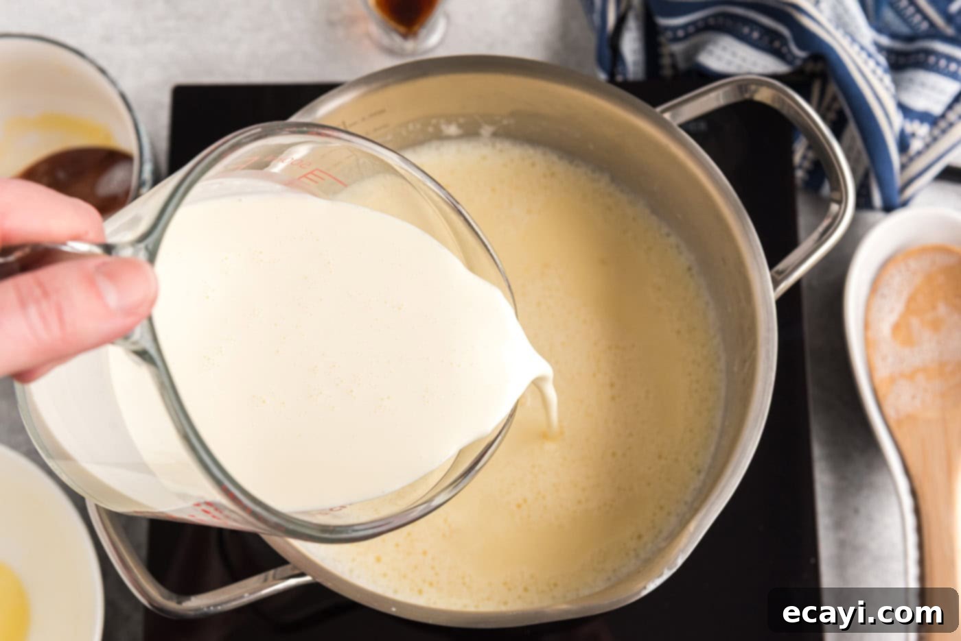 The Ultimate Homemade Vanilla Ice Cream 8 pouring heavy cream into saucepan of egg and milk mixture