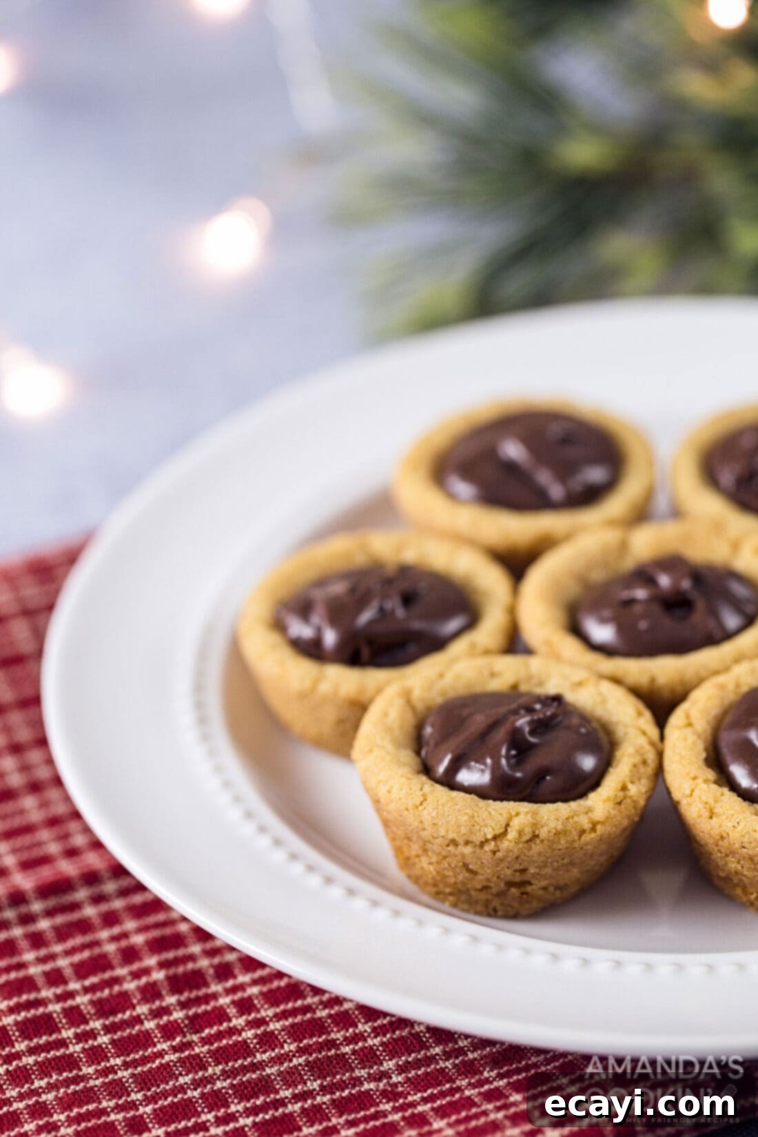 Fudgy Peanut Butter Delights 2 A plate of freshly baked peanut butter cookie cups with a rich, dark chocolate fudge filling
