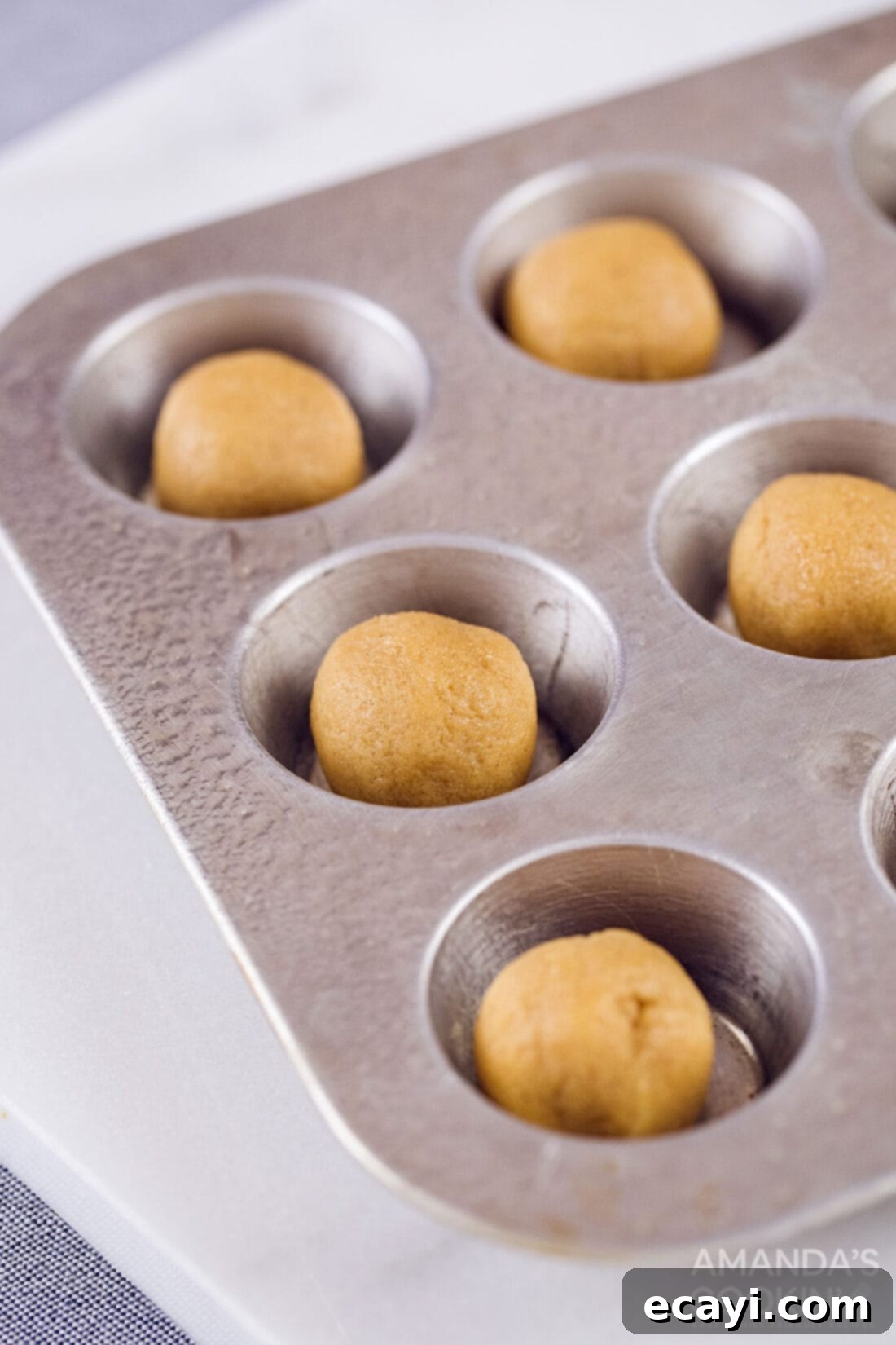 Fudgy Peanut Butter Delights 4 Mini muffin tin filled with perfectly portioned peanut butter cookie dough balls before baking