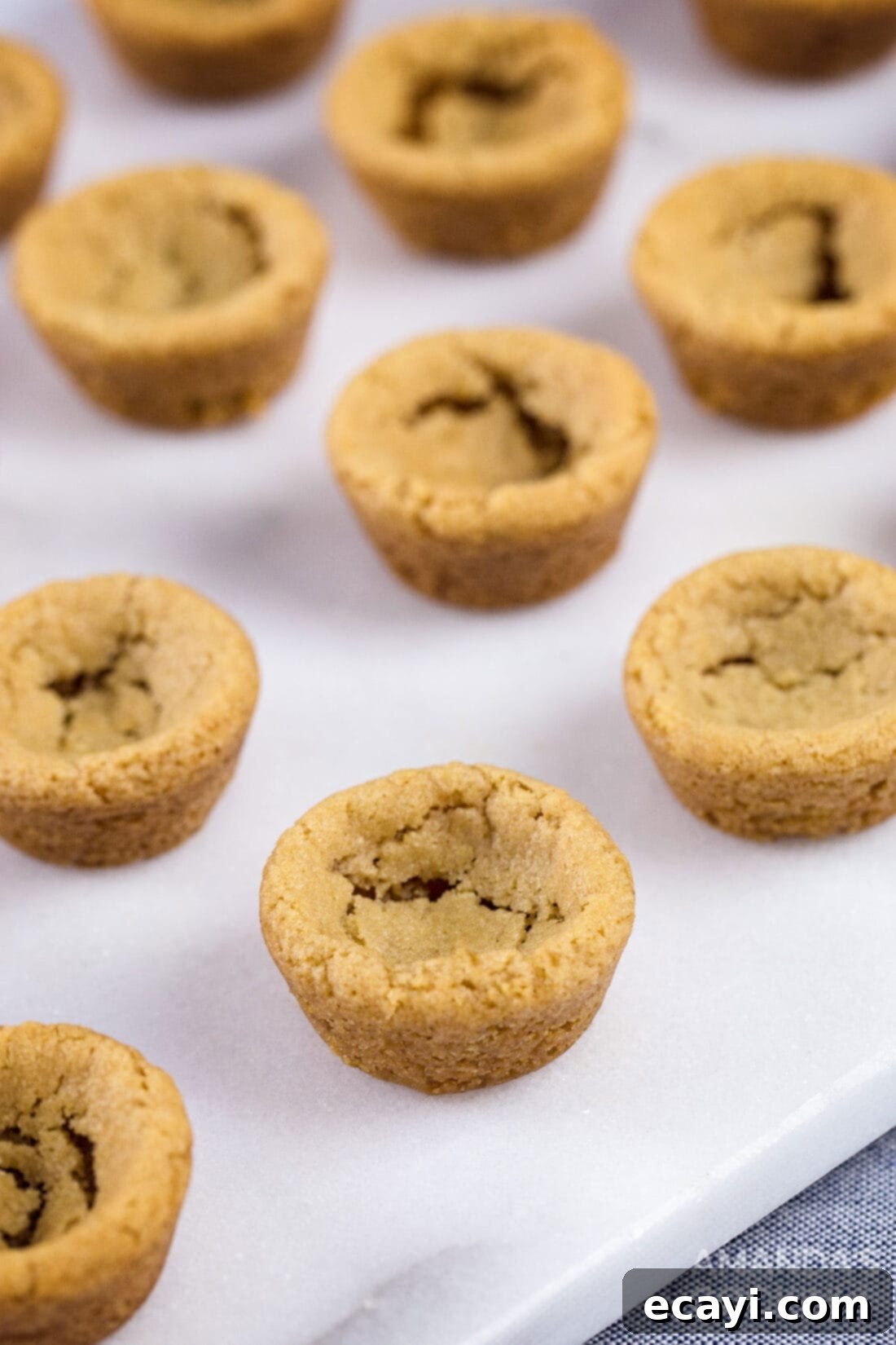 Fudgy Peanut Butter Delights 5 Warm, golden-brown peanut butter cookie cups fresh from the oven, ready for the fudge filling