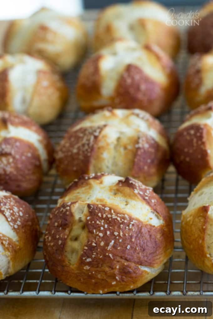 Pretzel Rolls 4 Three rows of perfectly baked bretzel rolls cooling on a wire rack, ready to be enjoyed.
