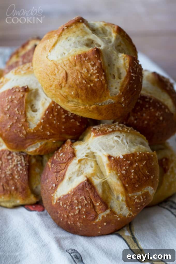 Pretzel Rolls 6 A close up of freshly baked bretzel rolls artfully arranged in a rustic bowl, highlighting their inviting texture and rich color.