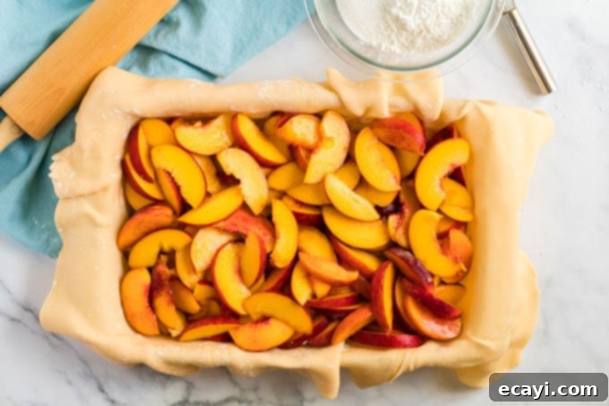 Heavenly Deep Dish Peach Pie 11 generous layer of thinly sliced peaches arranged within the pie dough in the baking pan