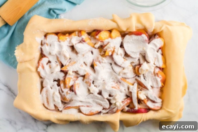 Heavenly Deep Dish Peach Pie 13 sugar mixture evenly sprinkled over the top of the sliced peaches in the baking pan