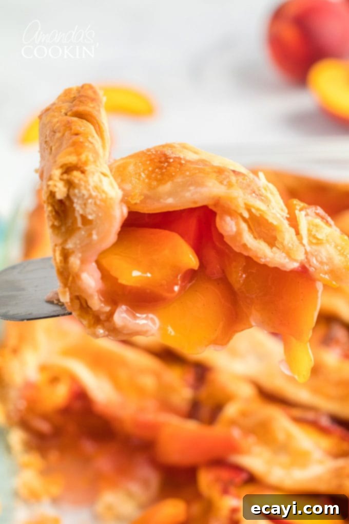 Heavenly Deep Dish Peach Pie 3 close up of a perfect slice of deep dish peach pie on a pie server, revealing juicy filling