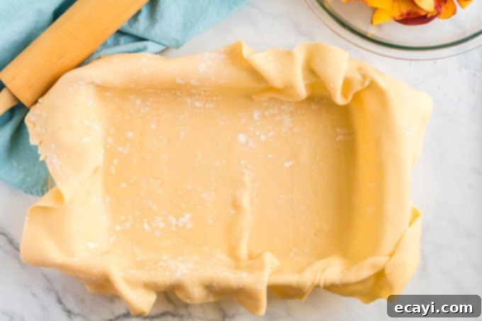 Heavenly Deep Dish Peach Pie 10 13x9 inch baking pan neatly lined with the prepared pie crust dough, awaiting the filling