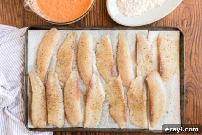 Your New Favorite Fish Tacos 6 fish strips on paper towels seasoned with salt and pepper, ready for battering