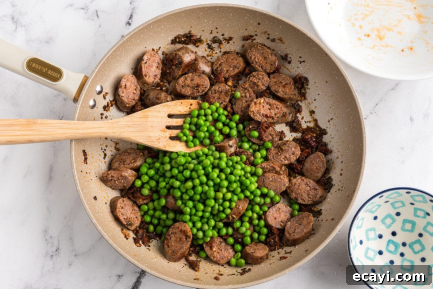 Hearty Sausage Penne With Peas 13 green peas added to Italian sausage and sun dried tomatoes in a skillet