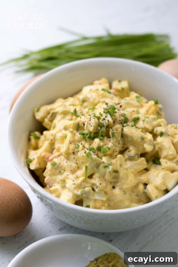 This Classic Creamy Egg Salad is made up of all the traditional ingredients from your favorite recipe. A perfect dish for any potluck or BBQ gathering! #eggsalad #BBQ #potluck #summerrecipes #appetizers #lunch Egg Salad with chives recipe - a classic dish for potlucks and BBQs, garnished with fresh herbs