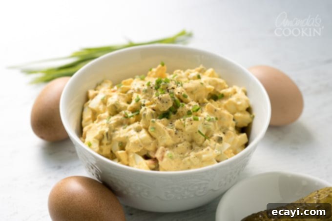 Egg salad with chives in a bowl, a classic recipe for any potluck or BBQ! #easter #easterrecipes #eggsalad #BBQ #potluck #summer #summerrecipes #appetizers #lunch Creamy egg salad with chives in a serving bowl, ready to enjoy as a light lunch or snack.