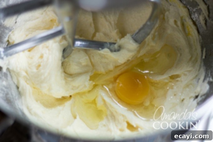 Decadent Tiramisu 4 A bowl of cake batter with eggs being added, showing the creamy texture.
