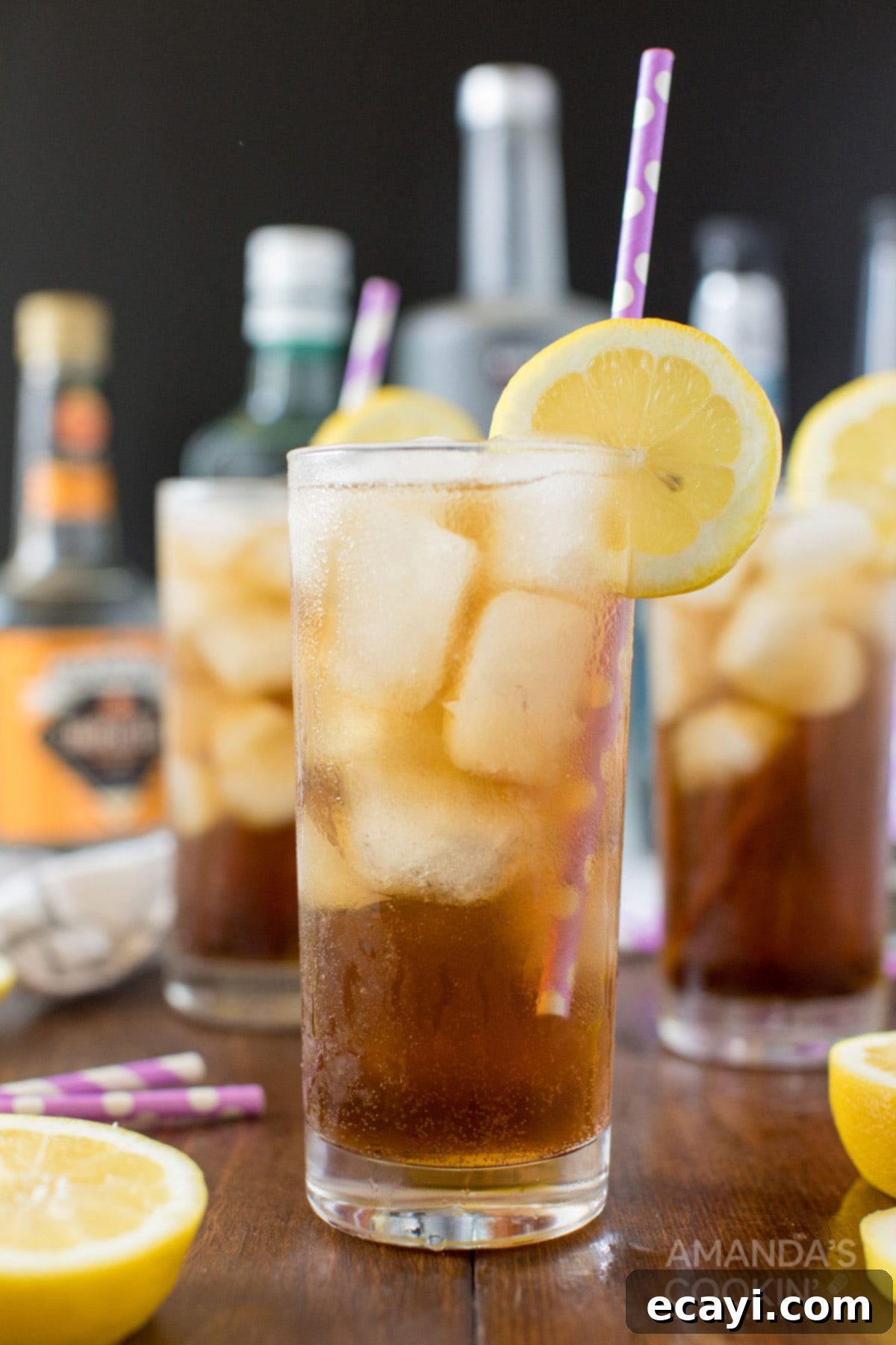 No Tea, All Buzz 2 A refreshing tall glass of Long Island Iced Tea garnished with a lemon slice and straw, ready to be enjoyed.