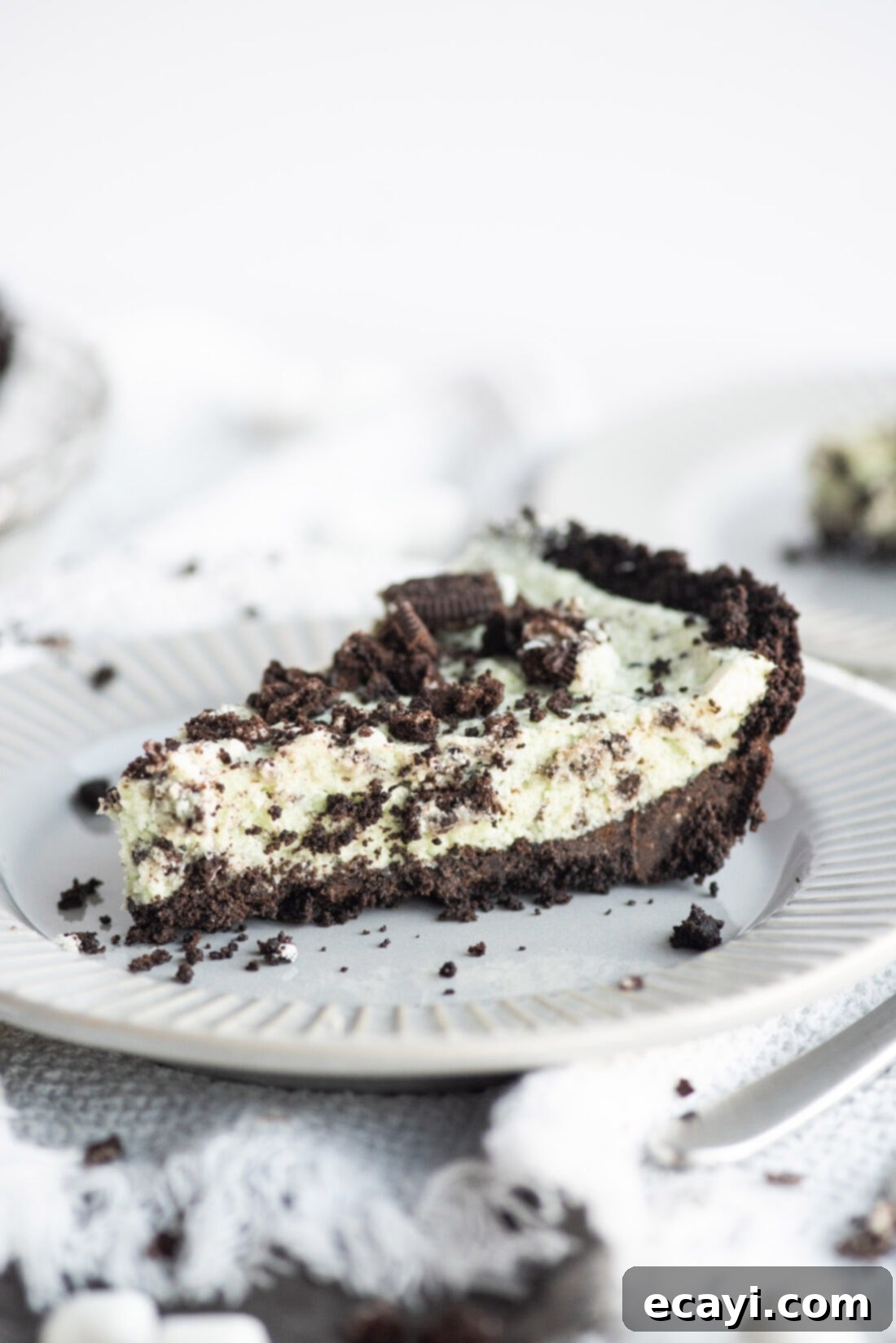Decadent Grasshopper Pie 11 A perfectly cut slice of vibrant green Grasshopper Pie, showcasing its creamy layers and chocolate crust, ready to be enjoyed.