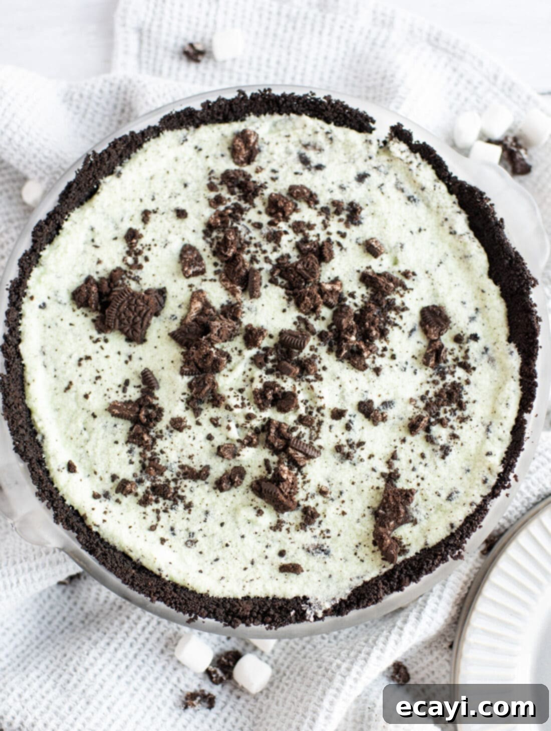 Decadent Grasshopper Pie 3 Overhead view of a whole Grasshopper Pie, showcasing its vibrant green filling, chocolate Oreo crust, and a generous sprinkle of crushed Oreos on top.