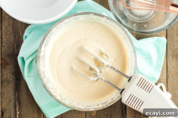 Timeless White Cake 4 white cake batter in a bowl with a mixer