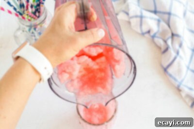 Kitchen Crafted Slush Floats 14 Pouring the red slushie from the blender into a glass, anticipating the addition of ice cream.