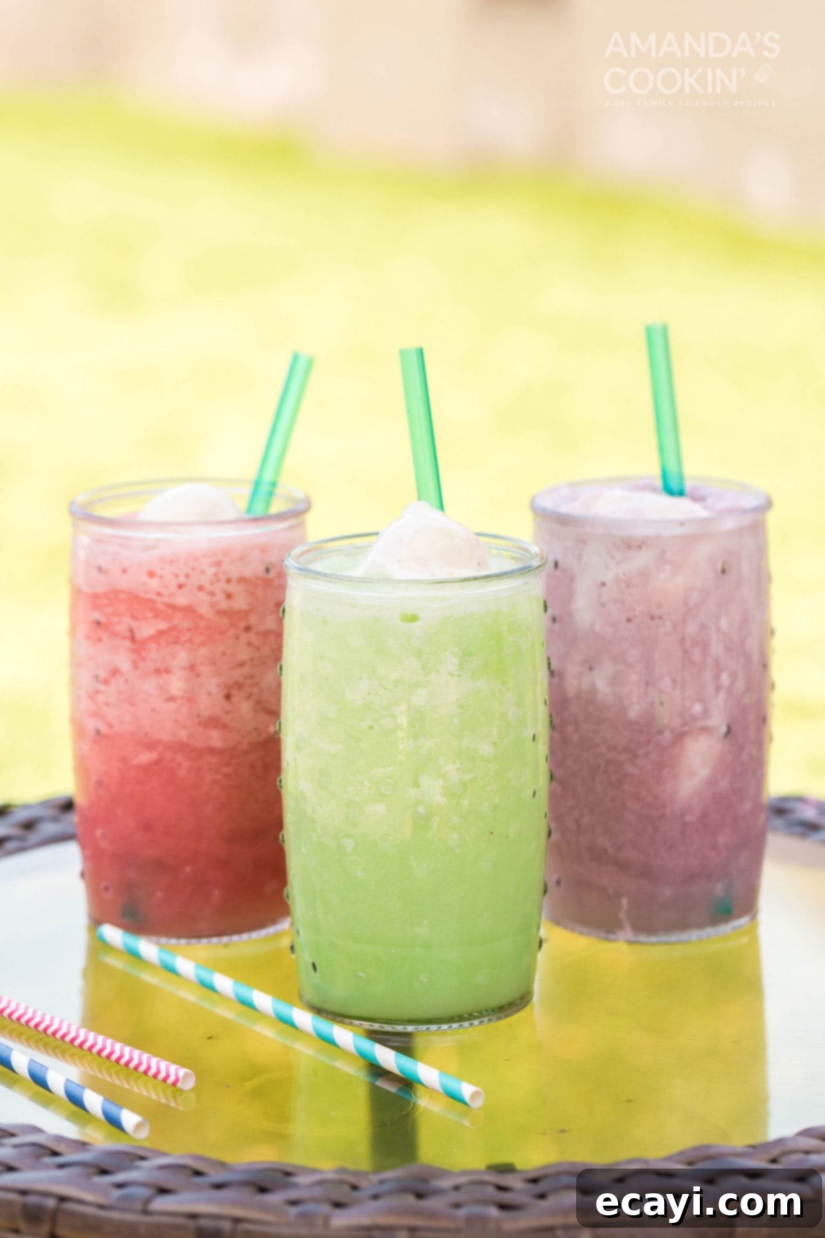 Refreshing Homemade Slushie Floats for the Whole Family Three colorful slushie floats, including red, orange, and green, with scoops of vanilla ice cream, sitting on an outdoor table, ready for summer enjoyment.