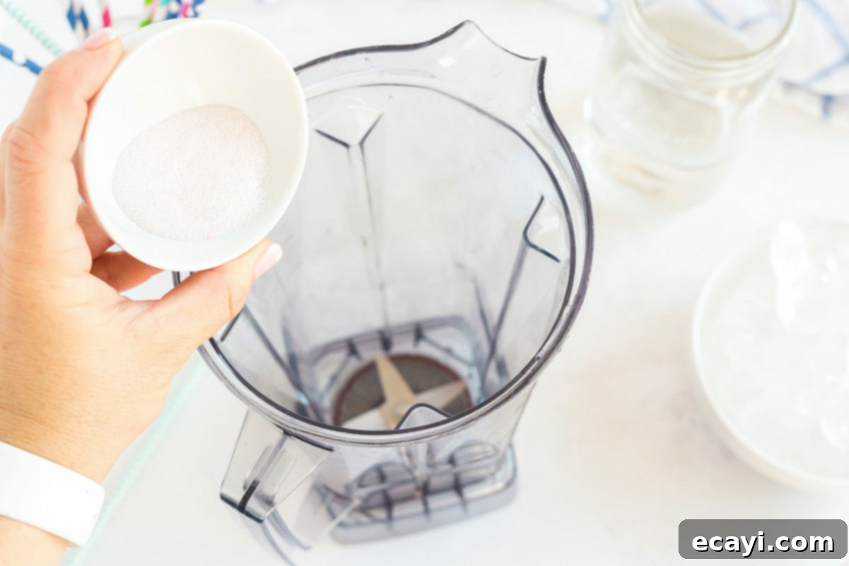 Kitchen Crafted Slush Floats 3 Adding red powdered drink mix to a blender with water.