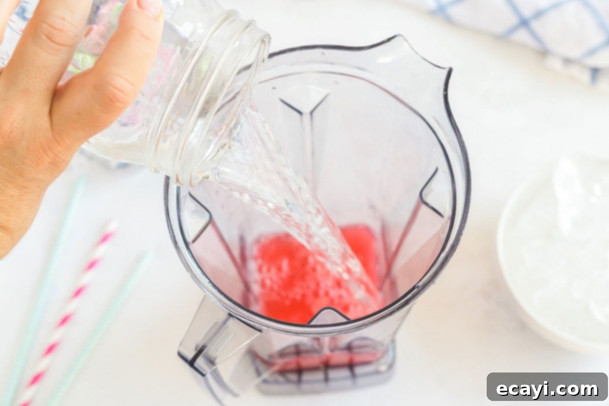 Kitchen Crafted Slush Floats 4 Pouring water into a blender alongside the drink mix.