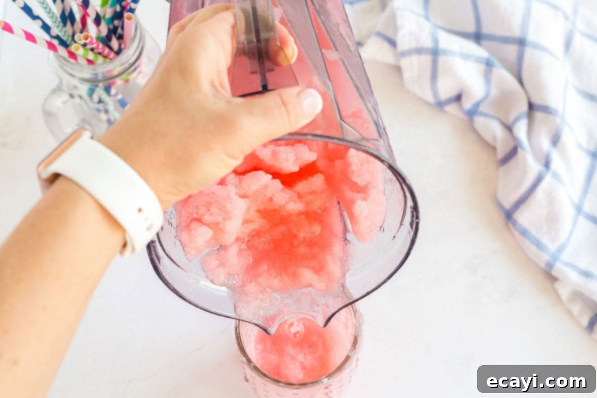Kitchen Crafted Slush Floats 8 Pouring the red slushie from the blender into a tall glass, ready for ice cream.