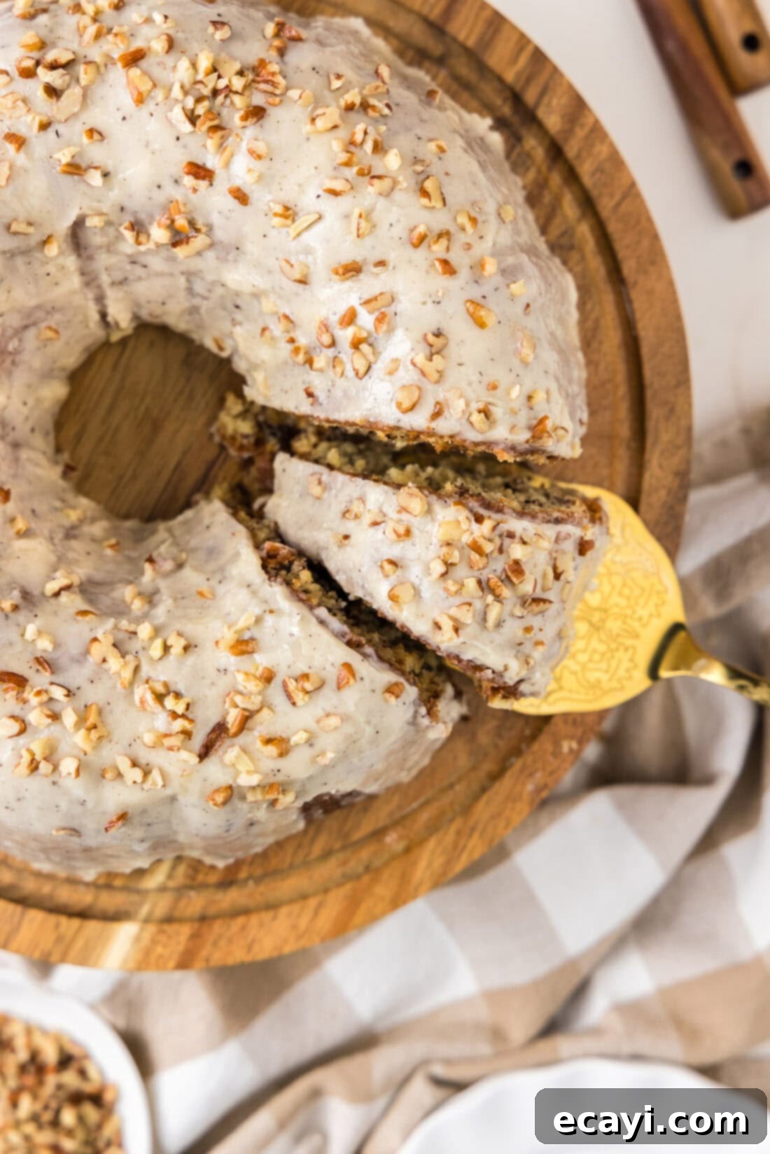 Velvet Banana Bundt 6 Overhead photo of a Banana Bundt Cake with a slice being removed, showing the tender crumb