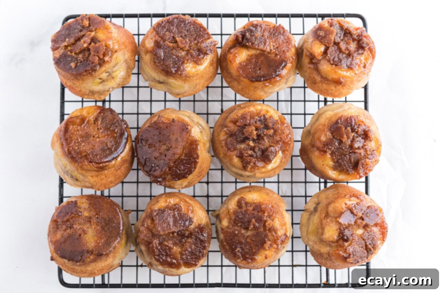 Sticky-Sweet Banana Crown Muffins 15 banana upside down muffins on a cooling rack after being inverted