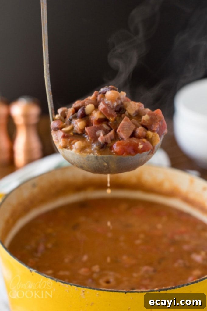 Hearty & Easy Ham and Bean Soup: The Ultimate Leftover Ham Recipe Steaming ladle of ham and bean soup, garnished with fresh herbs, showcasing its rich texture and warmth.
