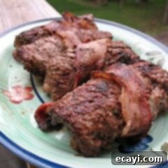 Grilled Cube Steak Roll-Ups 2 A close up photo of grilled cube steak rollups on a decorative green plate.