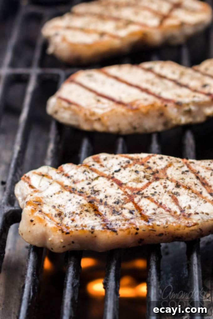 Achieve the perfect grilled pork chops every time with this easy lemon herb marinade. Discover the secret to juicy, flavorful pork chops that are ideal for any occasion. Perfectly grilled pork chops resting on a cutting board, ready to be sliced and served.