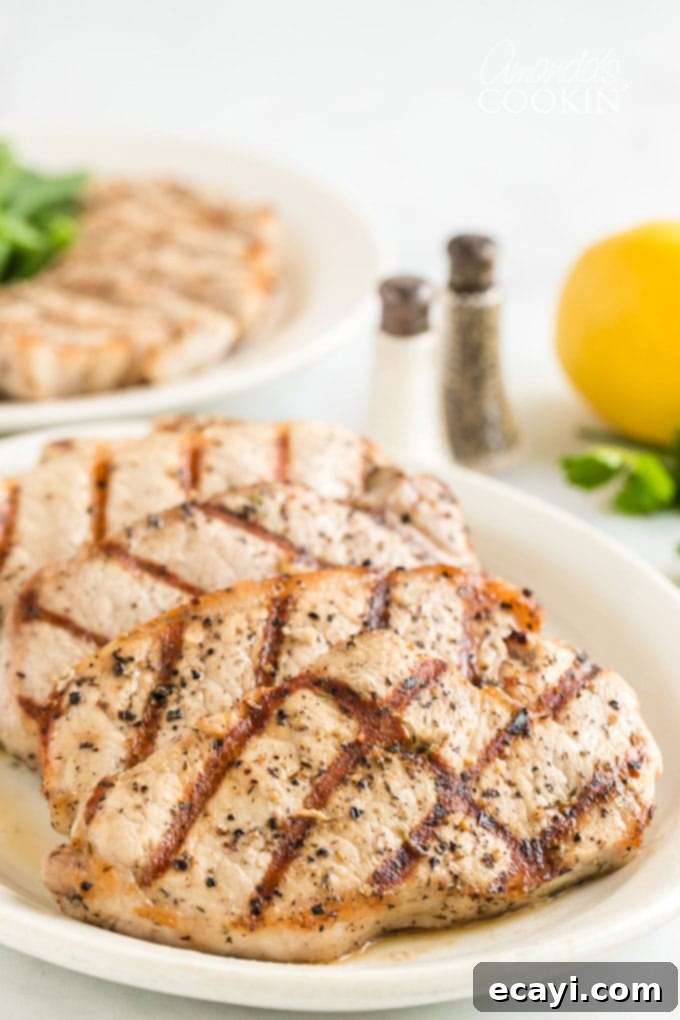 Master the art of grilling with these perfect pork chops. Our lemon herb marinade ensures they are always juicy and full of flavor. A beautiful platter of golden-brown grilled pork chops, garnished with fresh herbs, ready for serving.