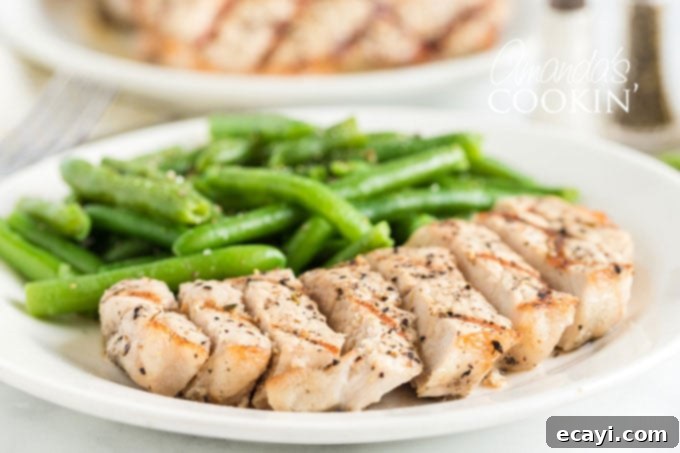 Enjoy a perfectly grilled and sliced pork chop, a testament to a great recipe and expert grilling techniques. A perfectly cooked, sliced pork chop presented on a plate, showcasing its tender texture and readiness to eat.