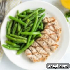 Zesty Herb Grilled Pork Chops 2 A plate featuring a perfectly grilled pork chop with fresh green beans, showcasing a delicious and healthy meal.