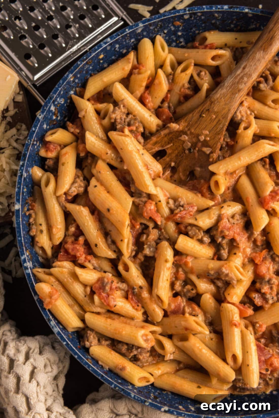 Tomato Sage Sausage Penne 13 Close up photo of Penne with Tomato Sage Sausage Sauce in a skillet with a spoon, highlighting the creamy texture