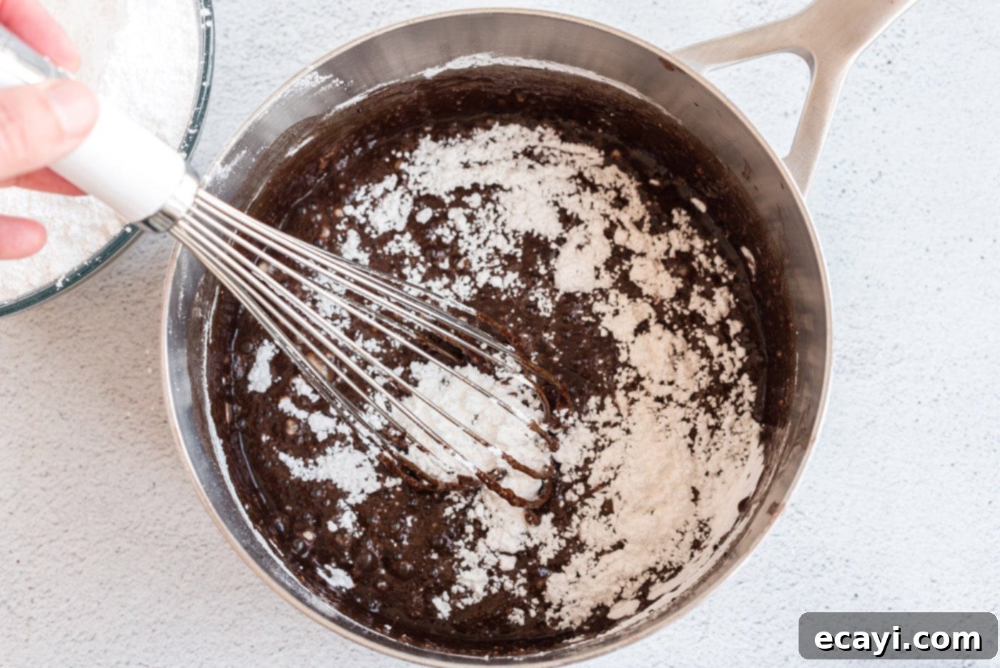 Texas-Sized Chocolate Dream 12 whisking chocolate fudge frosting in a saucepan
