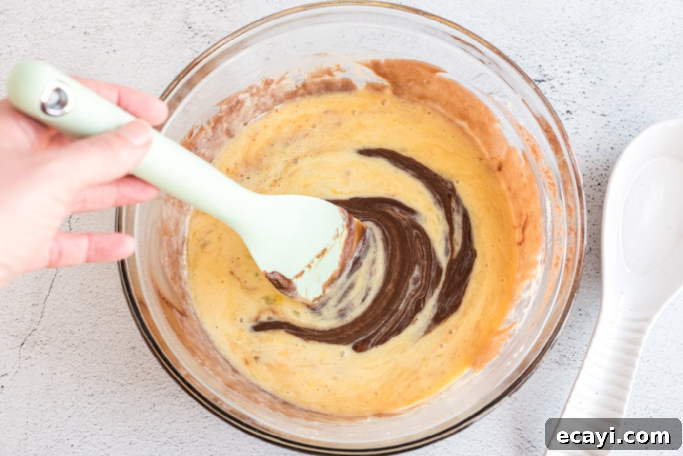 Texas-Sized Chocolate Dream 10 mixing sheet cake batter in a bowl with a spatula