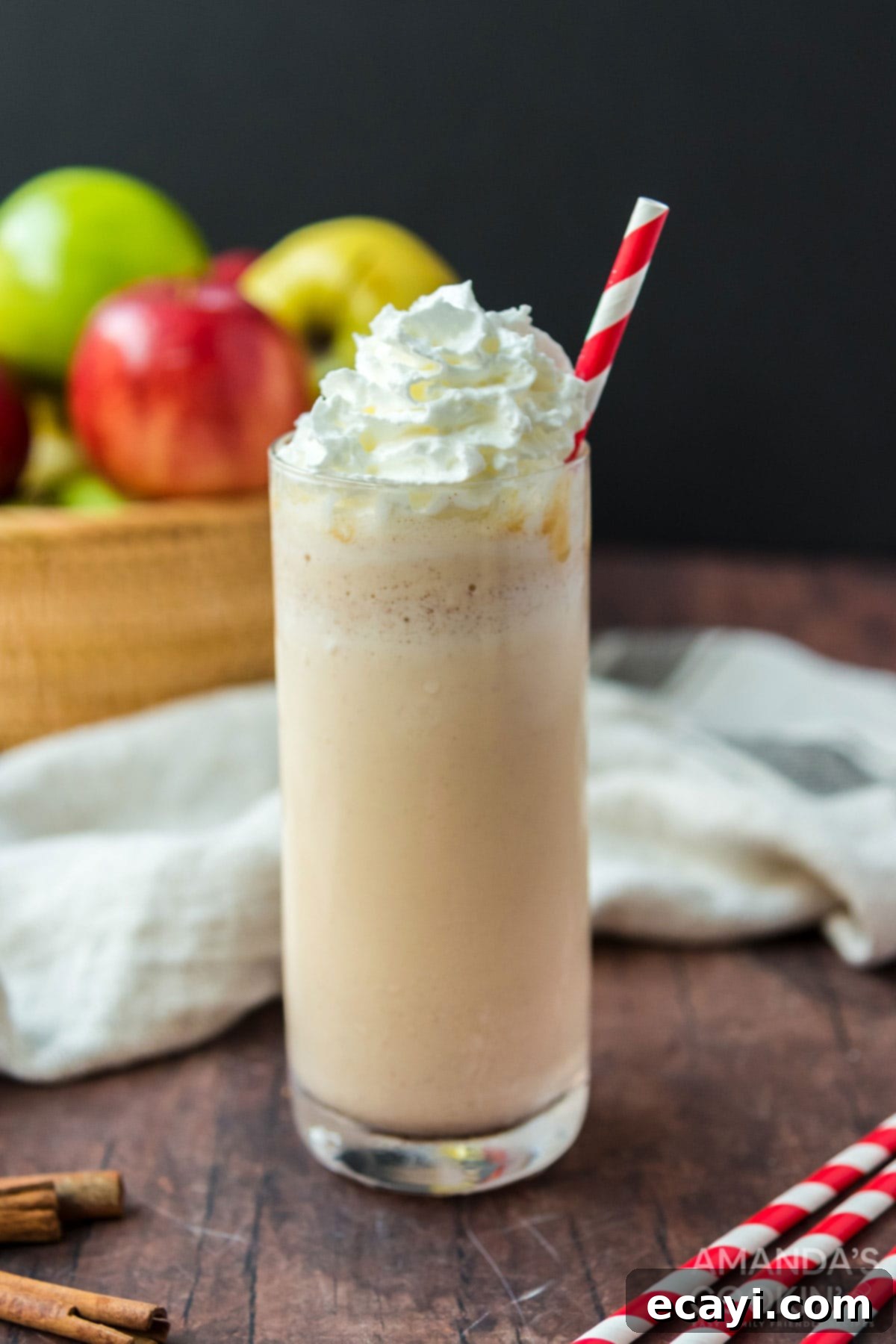 Only 3 ingredients for this delicious, fall inspired apple cider milkshake. So easy to make and an amazing way to wrap up summer. Close-up of an apple cider milkshake in a tall glass, with whipped cream and a cinnamon stick garnish