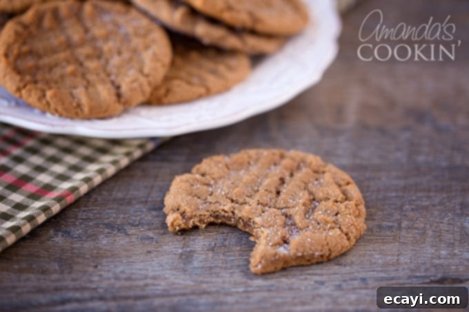Decadent Nutella Peanut Butter Cookies 3 A vibrant photo of several Nutella Peanut Butter Cookies, perfectly golden brown with distinct criss-cross patterns, ready to be enjoyed.